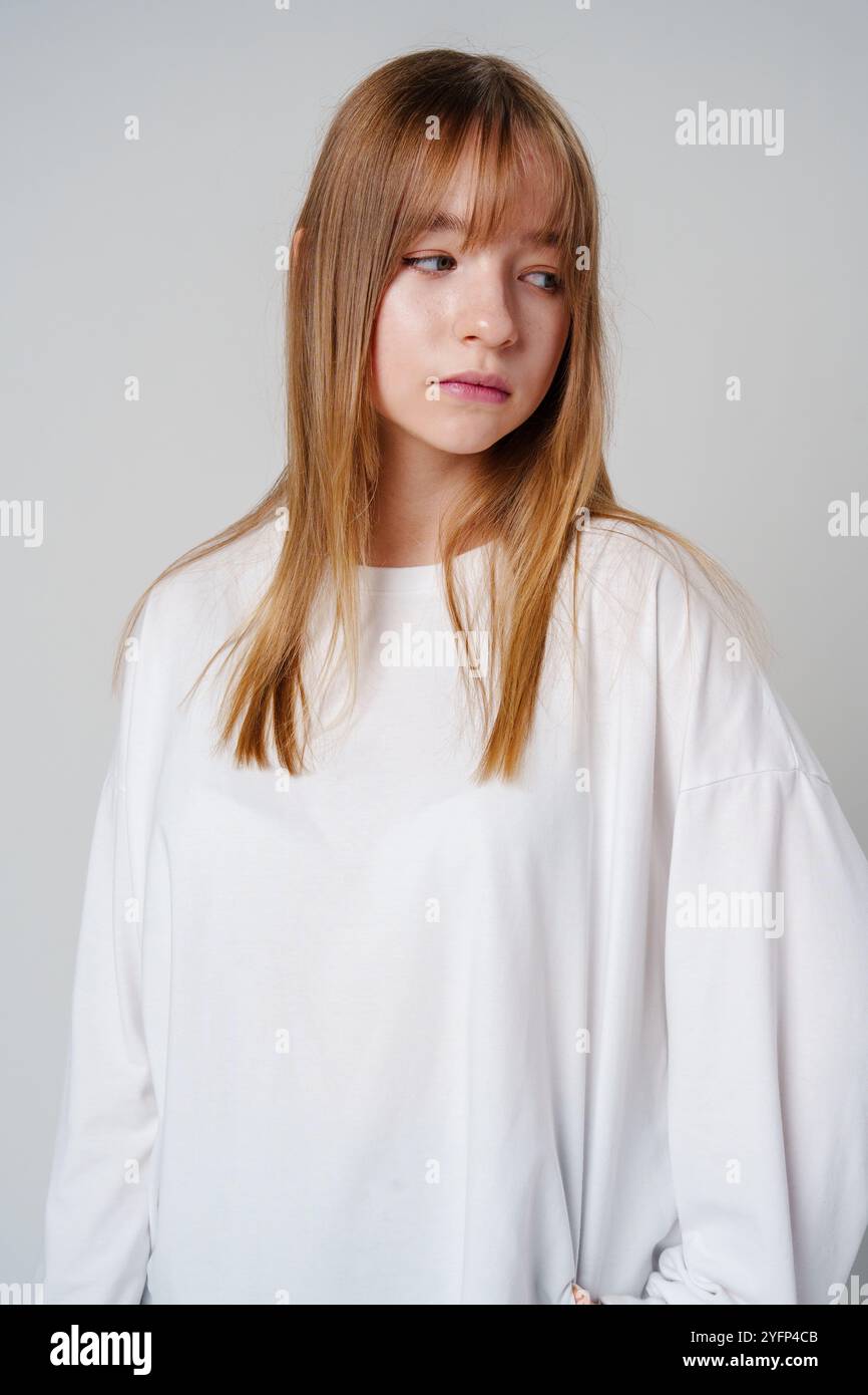 Casual portrait of a young girl wearing a white long-sleeve shirt and ...