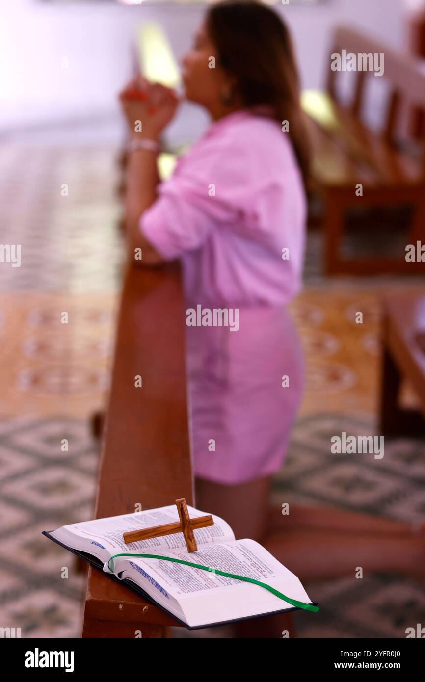 Catholic woman praying in a church. Bible and christian cross Stock ...
