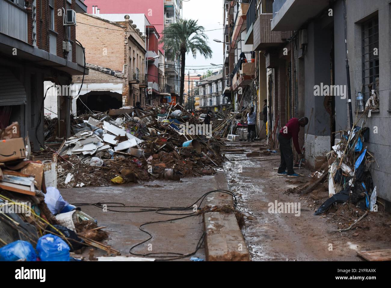 Paiporta, Valencia, Spain - Nov 4, 2024. Effects of DANA in Paiporta, the epicenter of disaster, where the water of ravines rose to level of streets causing flooding that covered the houses of inhabitants. Commerces were destroyed, cars dragged by the unstoppable flow of water and debris. Railway tracks at metro station are hanging several meters above the ravine bed. Excavators and heavy machinery are working day and night to pile up rubble. Locals are bringing out of their houses all furniture and personal belongings. Credit: Roberto Arosio/Alamy Live News Stock Photo