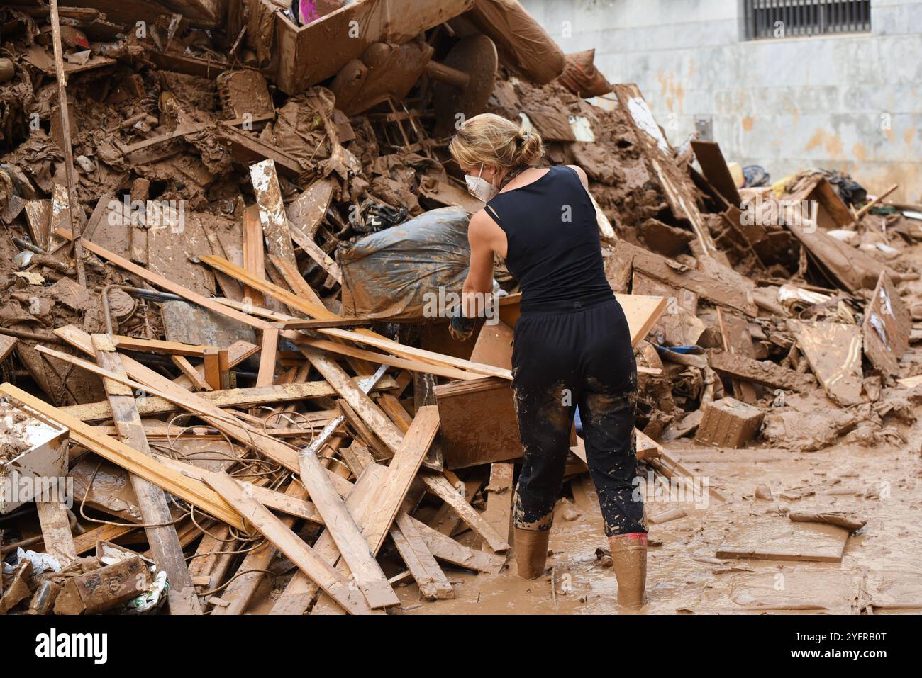 Paiporta, Valencia, Spain - Nov 4, 2024. Effects of DANA in Paiporta, the epicenter of disaster, where the water of ravines rose to level of streets causing flooding that covered the houses of inhabitants. Commerces were destroyed, cars dragged by the unstoppable flow of water and debris. Railway tracks at metro station are hanging several meters above the ravine bed. Excavators and heavy machinery are working day and night to pile up rubble. Locals are bringing out of their houses all furniture and personal belongings. Credit: Roberto Arosio/Alamy Live News Stock Photo