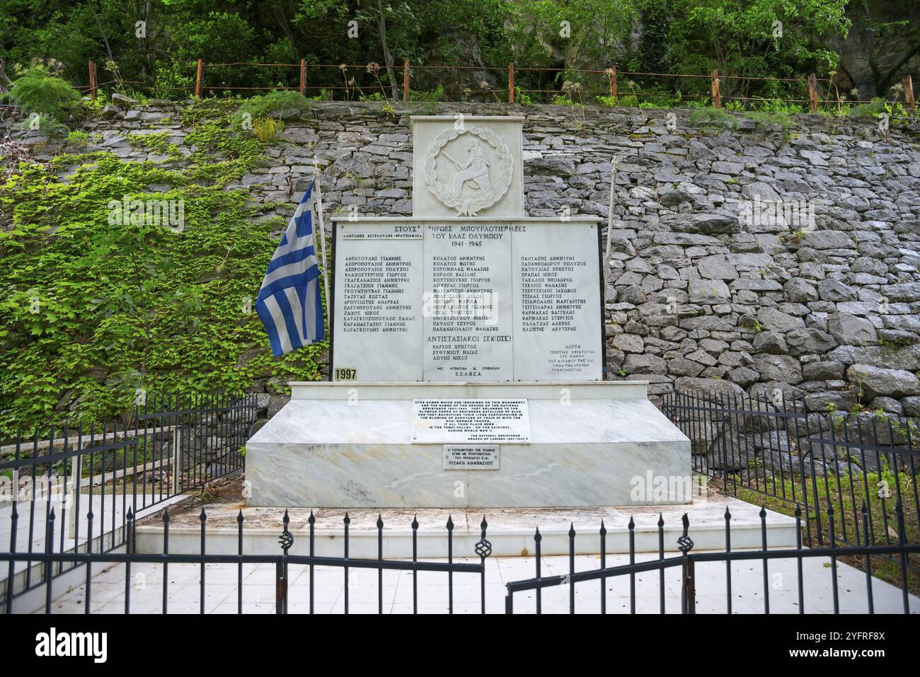 Memorial stone with inscription behind fence, surrounded by stone wall and flag, commemorating the fallen in World War II, Tempe Valley, Tembi Valley Stock Photo