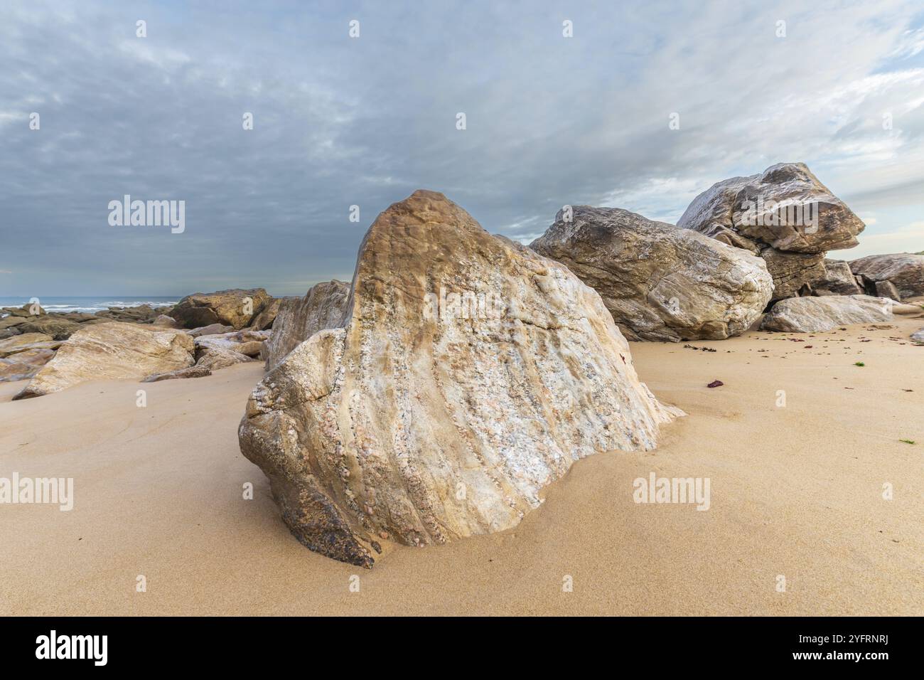 Rocks polished by waves of Atlantic Ocean on sandy beach. Sables d ...