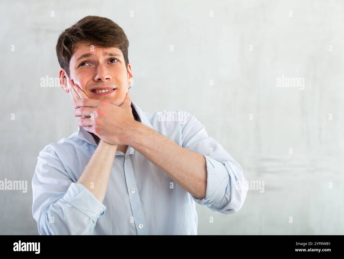 Young guy holding his cheek with toothache Stock Photo