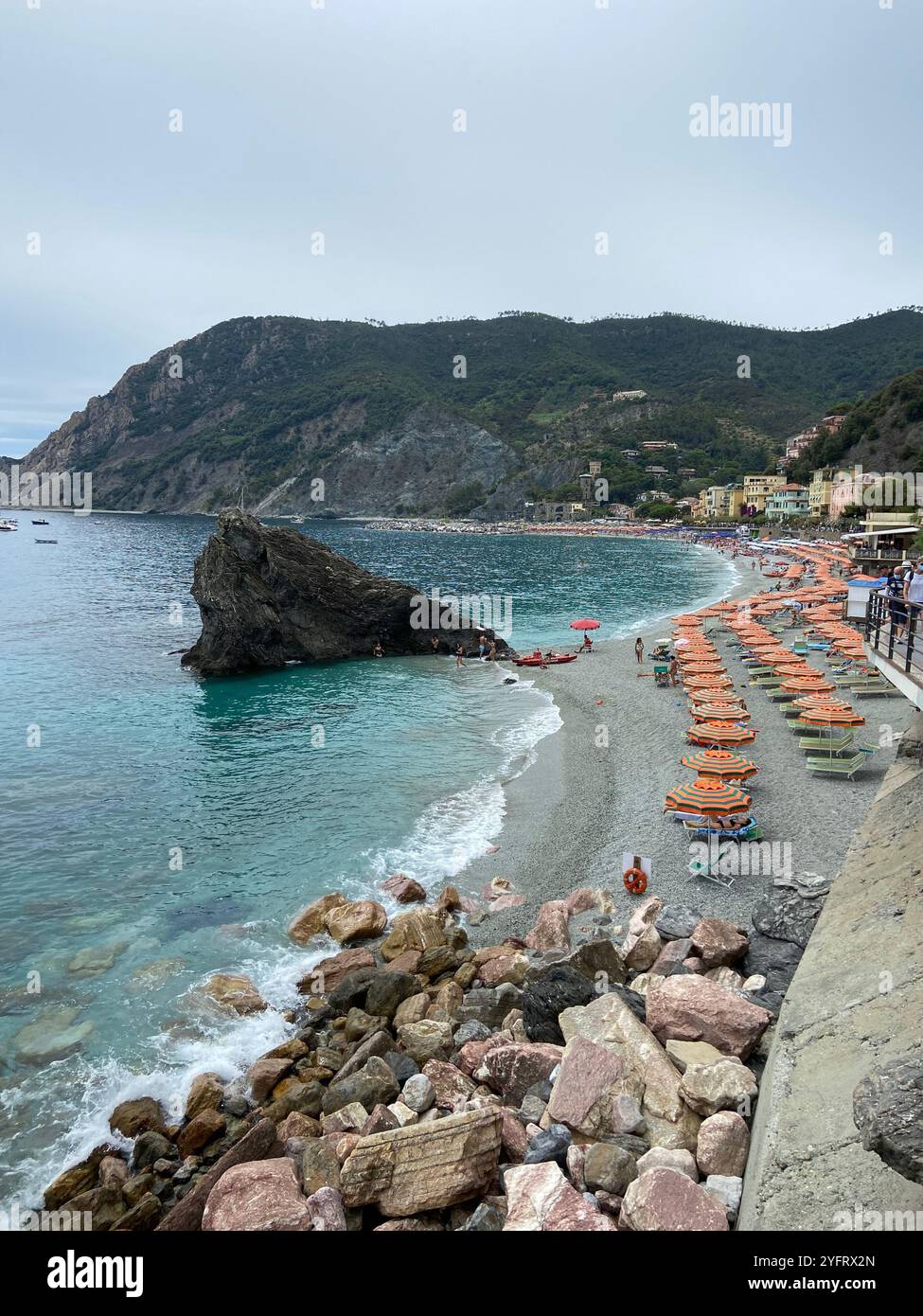 View of the beach and hills on a cloudy summer day in Monterosso al Mare, Cinque Terre, Liguria, Italy - Smartphone Captured Stock Image
