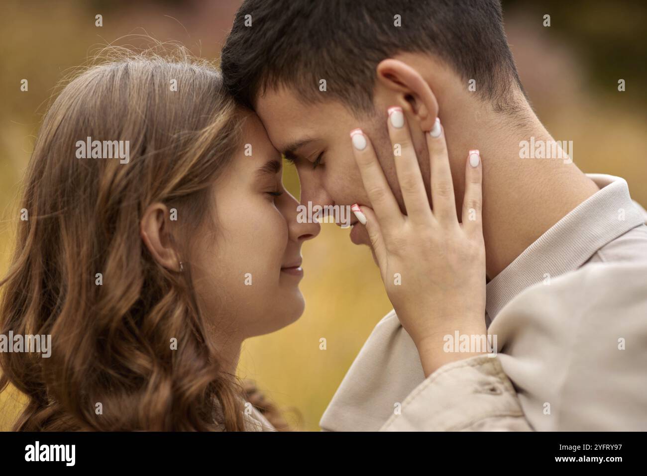 Young Cute Female Hugs Boyfriend. In Autumn Outdoor. Lovers Walking in Park. Attractive Funny Couple. Lovestory in Forest. Man and Woman. Cute Lovers Stock Photo