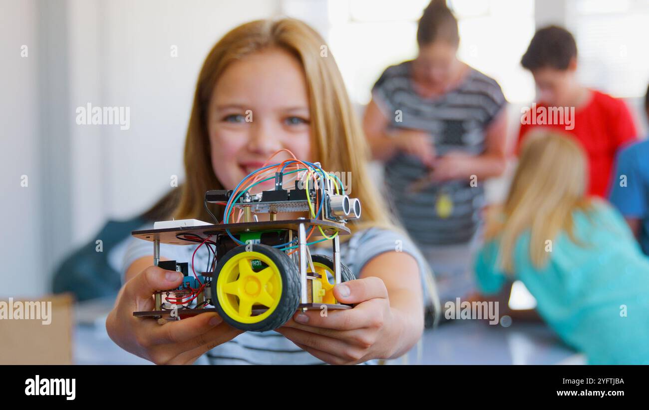 Portrait Of Smiling Female Student Holding Robot Vehicle In School ...