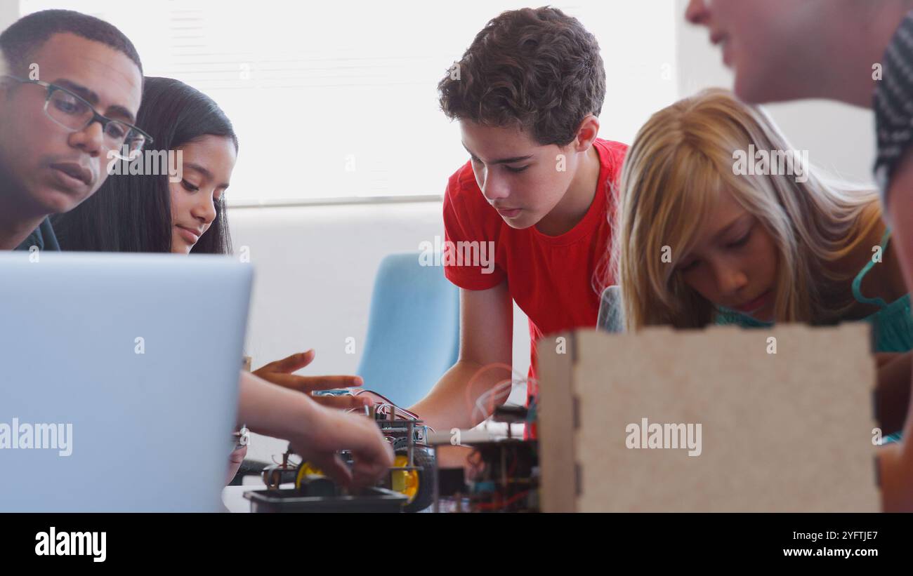 Students With Male Teacher In School Computer Coding Class Learn To Program Robot Vehicle Stock Photo