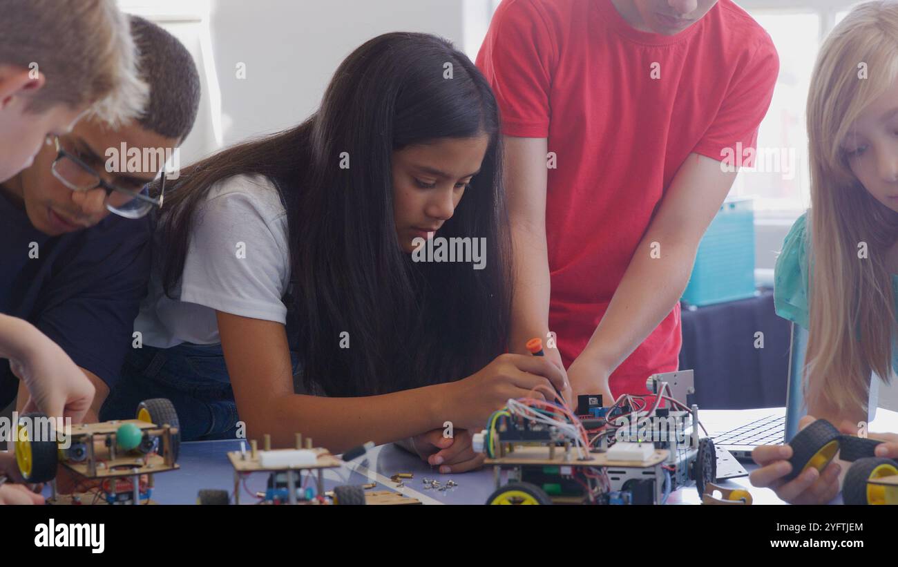 Students With Male Teacher In School Computer Coding Class Learn To Program Robot Vehicle Stock Photo