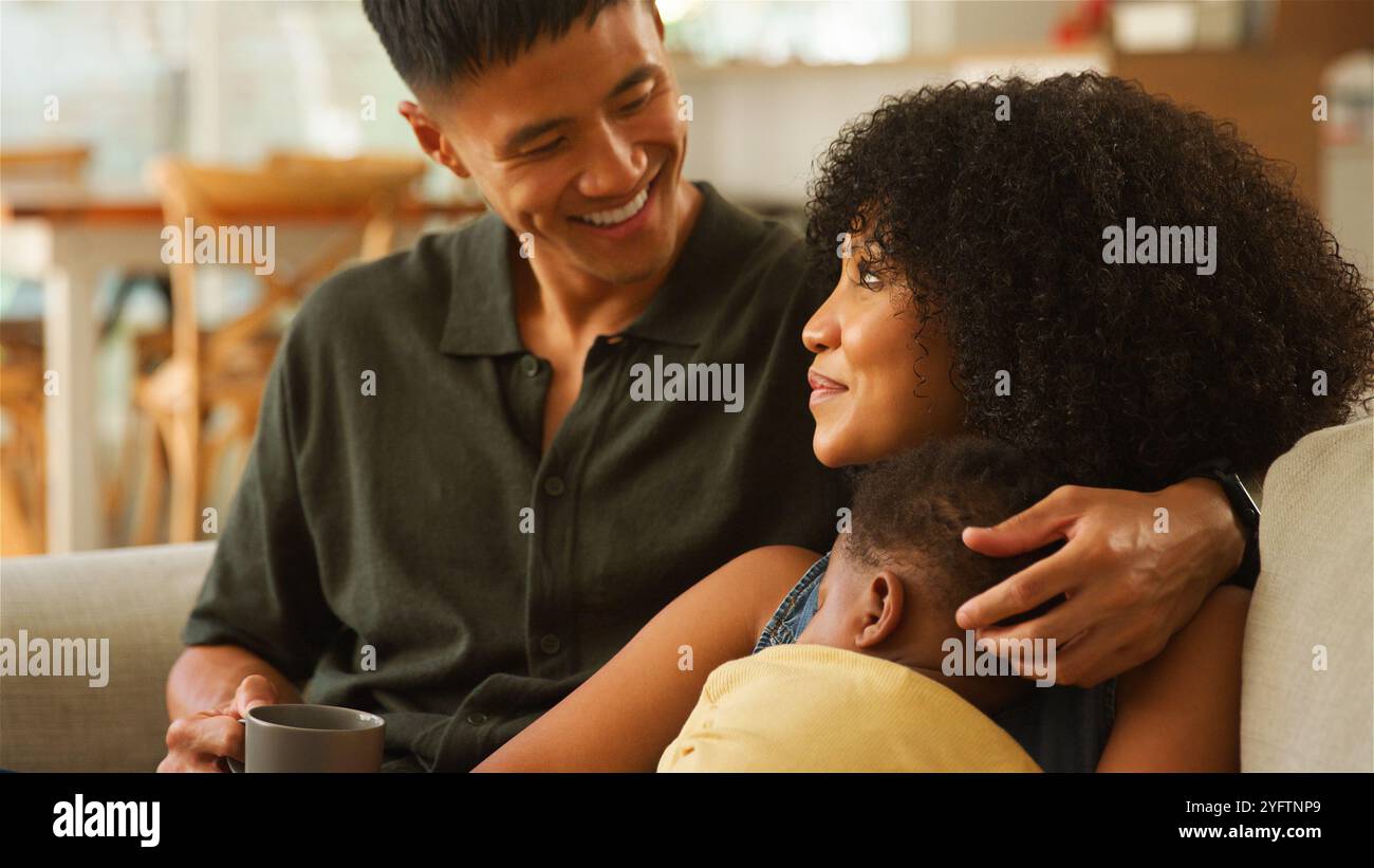 A joyful family moment unfolds as a father, mother, and their young ...
