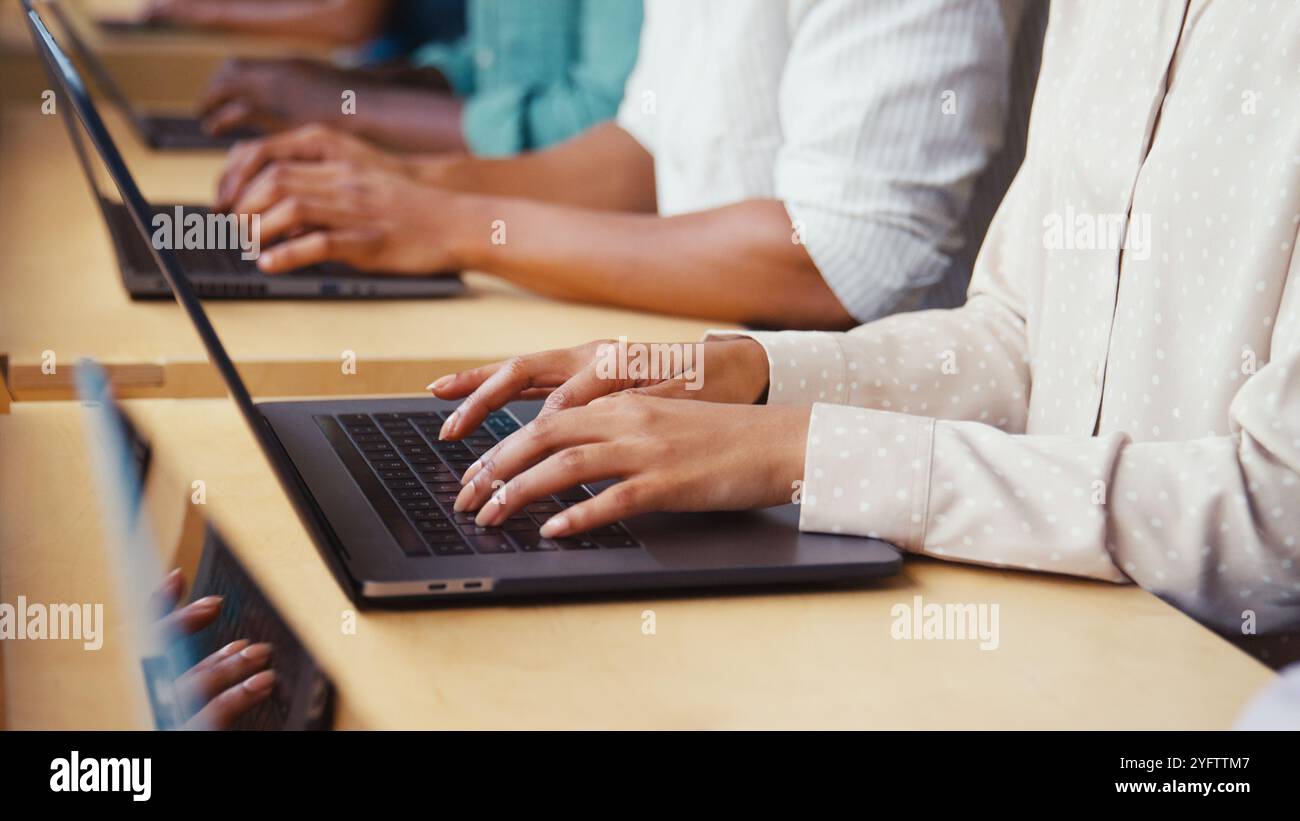 Close Up Of Multi-Cultural Business Team Typing On Laptop Computer Keyboard In Modern Office Stock Photo