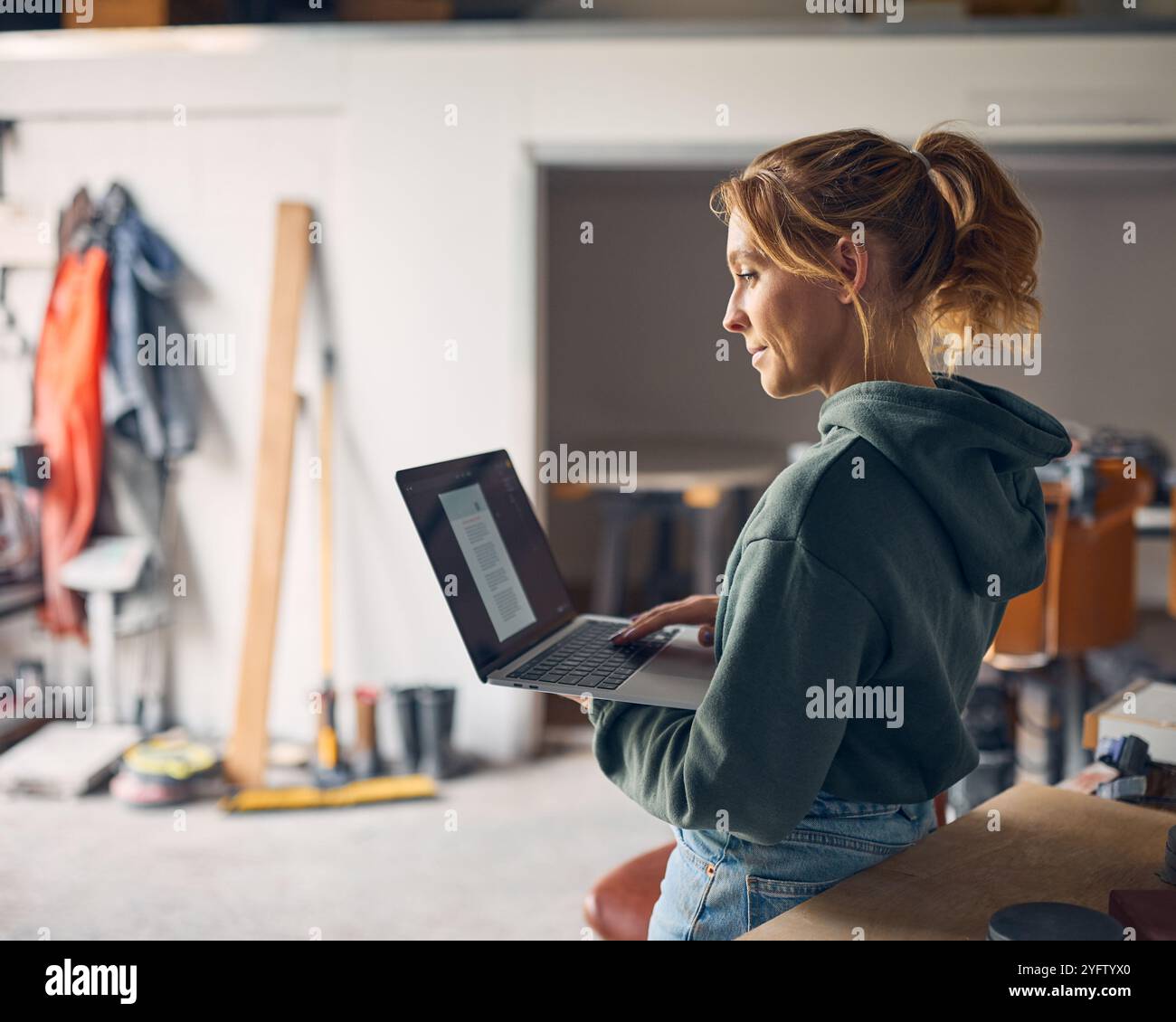 Female Worker In Concrete Workshop Using Laptop Computer Stock Photo