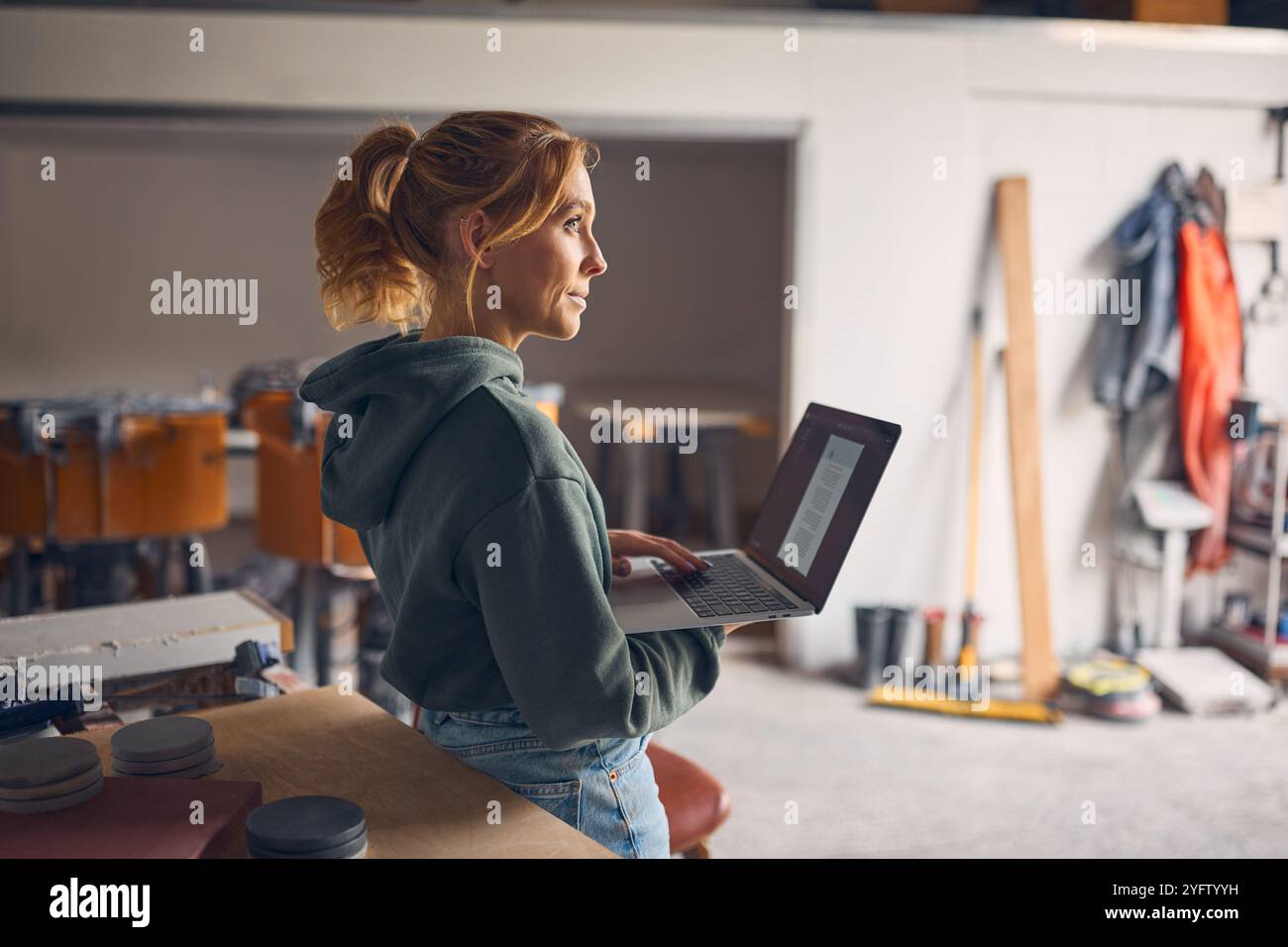 Female Worker In Concrete Workshop Using Laptop Computer Stock Photo