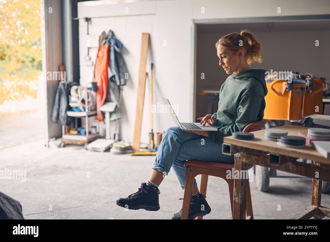 Female Worker In Concrete Workshop Using Laptop Computer Stock Photo