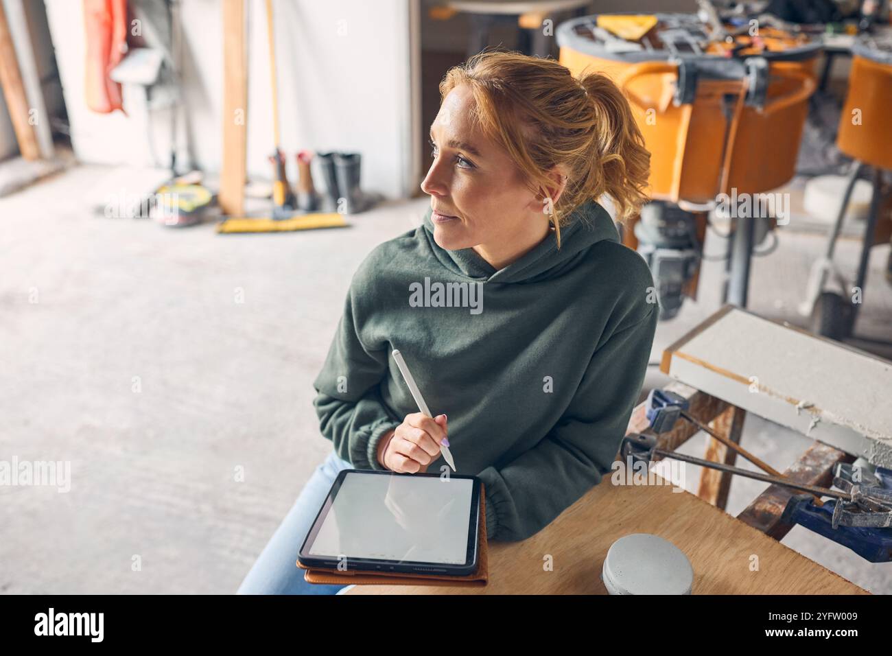 Female Worker In Concrete Workshop Using Digital Tablet And Stylus Stock Photo