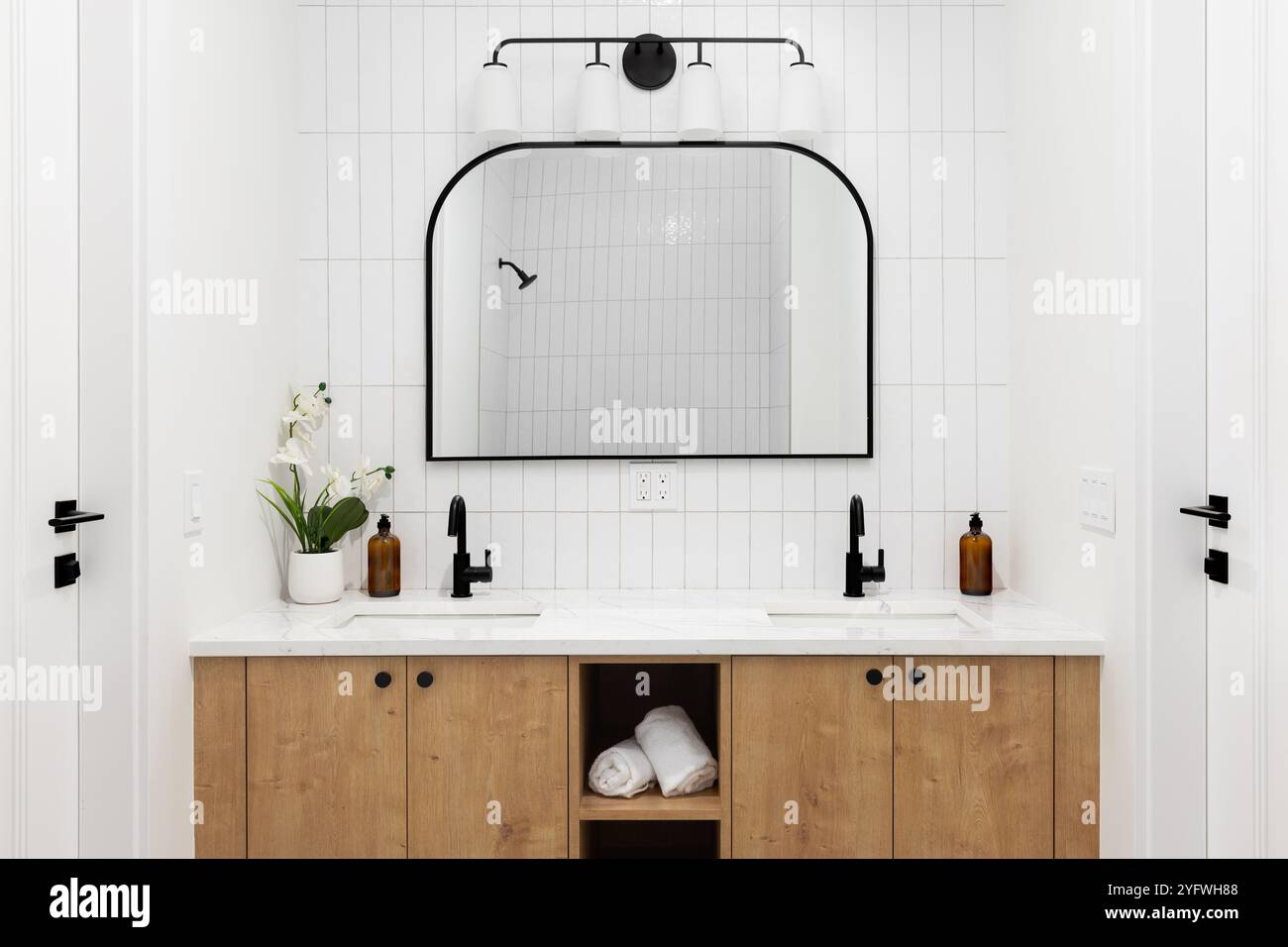 A modern farmhouse bathroom with a white oak cabinet, white marble ...
