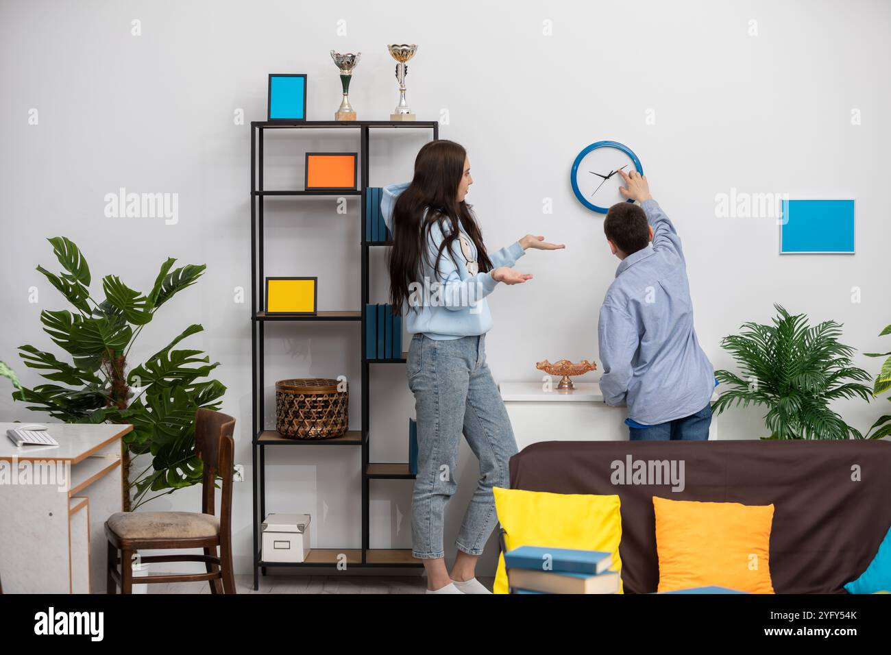 Creative friends collaborating to enhance a modern living room, making ...