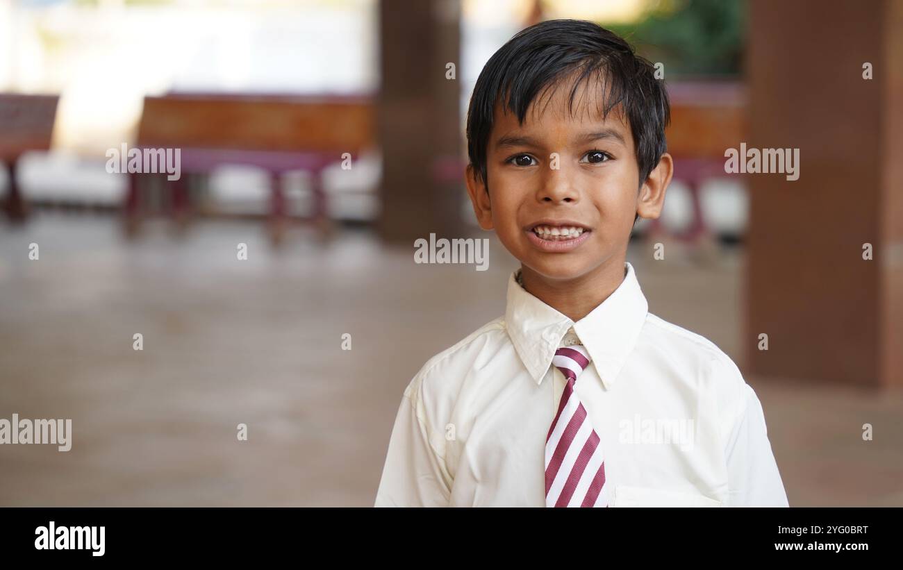 Happy Indian elementary school girls students sitting at desk in classroom with writing in notebook with pencil, Examination and test, female Educatio Stock Photo