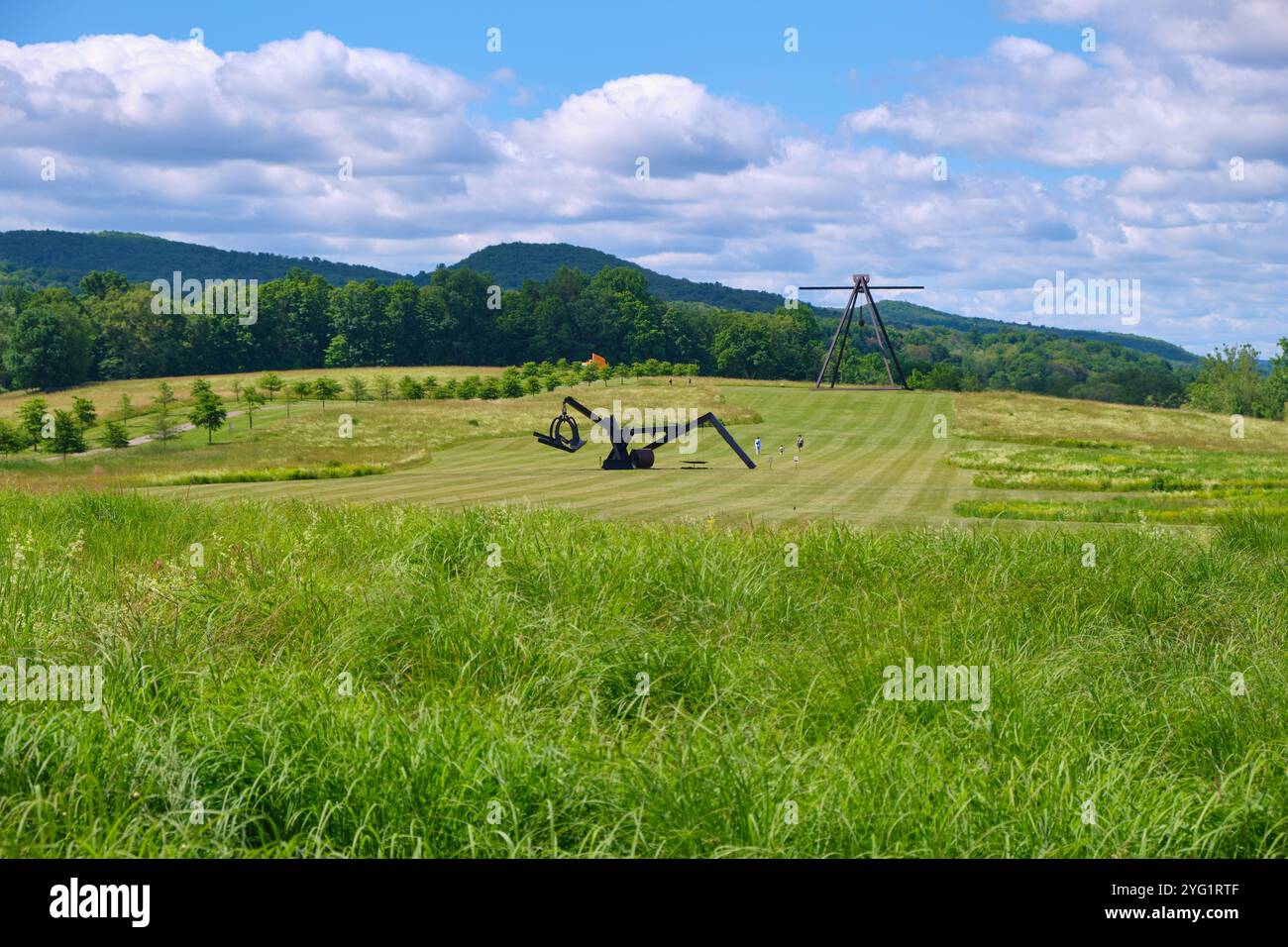 Visitors enjoying the lawns, fields, grass with monumental sculptures, including by Mark di Suvero. At Storm King Art Center in New Windsor, New York. Stock Photo