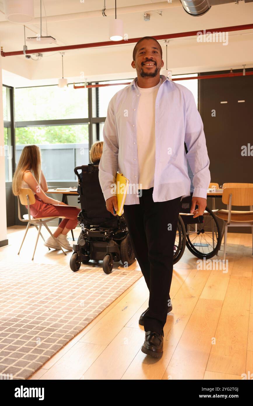 Businessman walking through office Stock Photo
