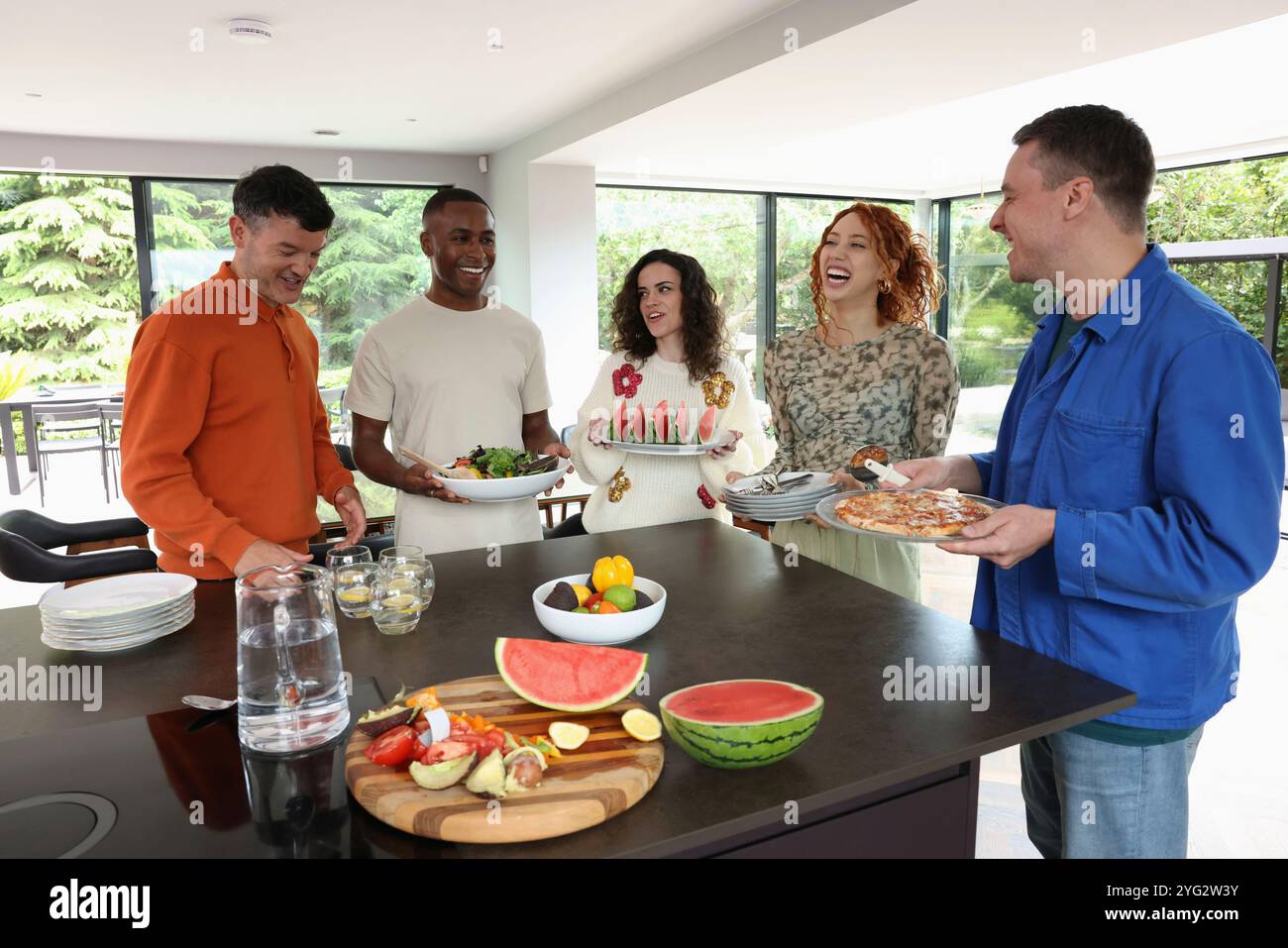 Friends preparing food in kitchen Stock Photo