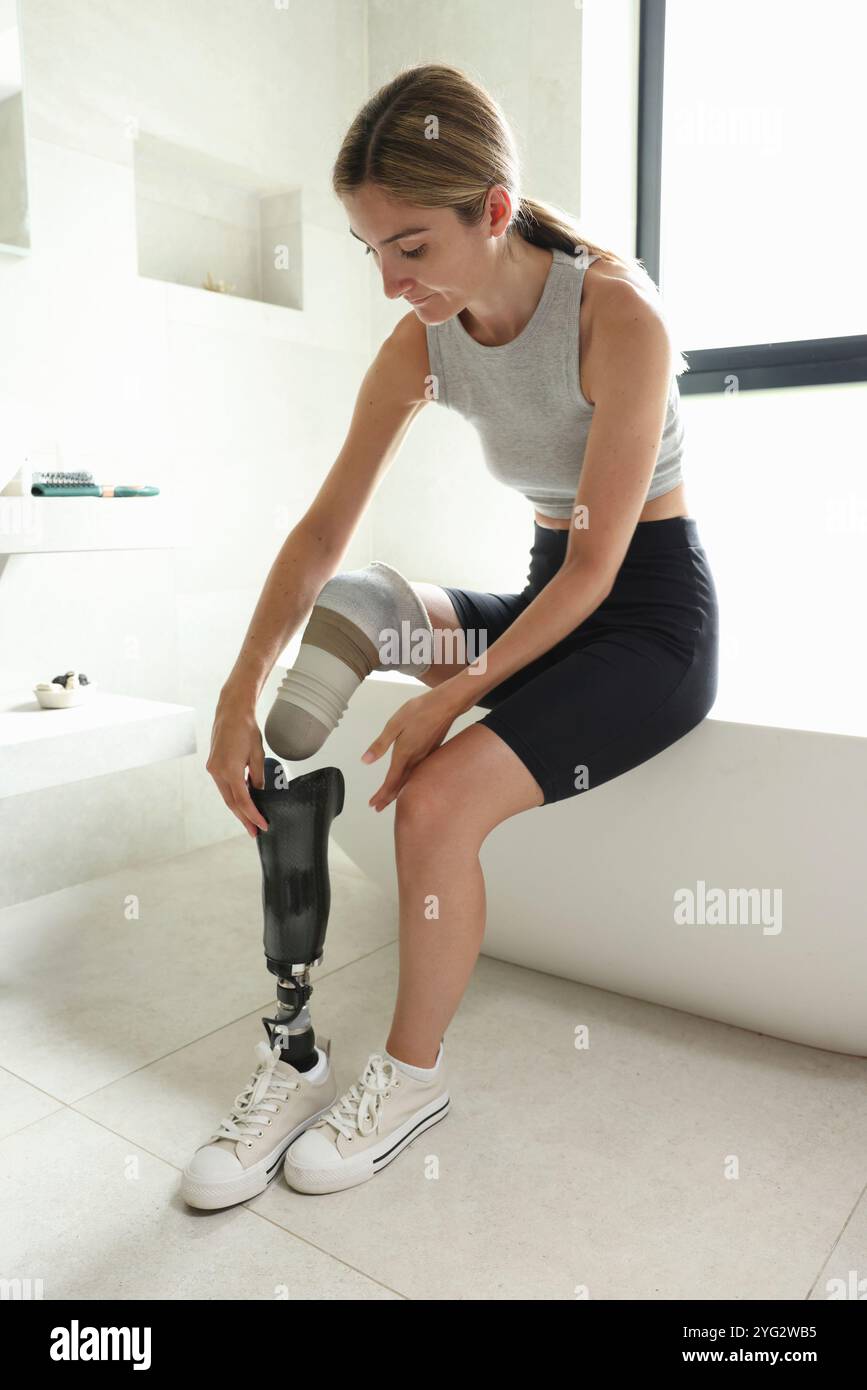Woman putting on leg prosthesis Stock Photo