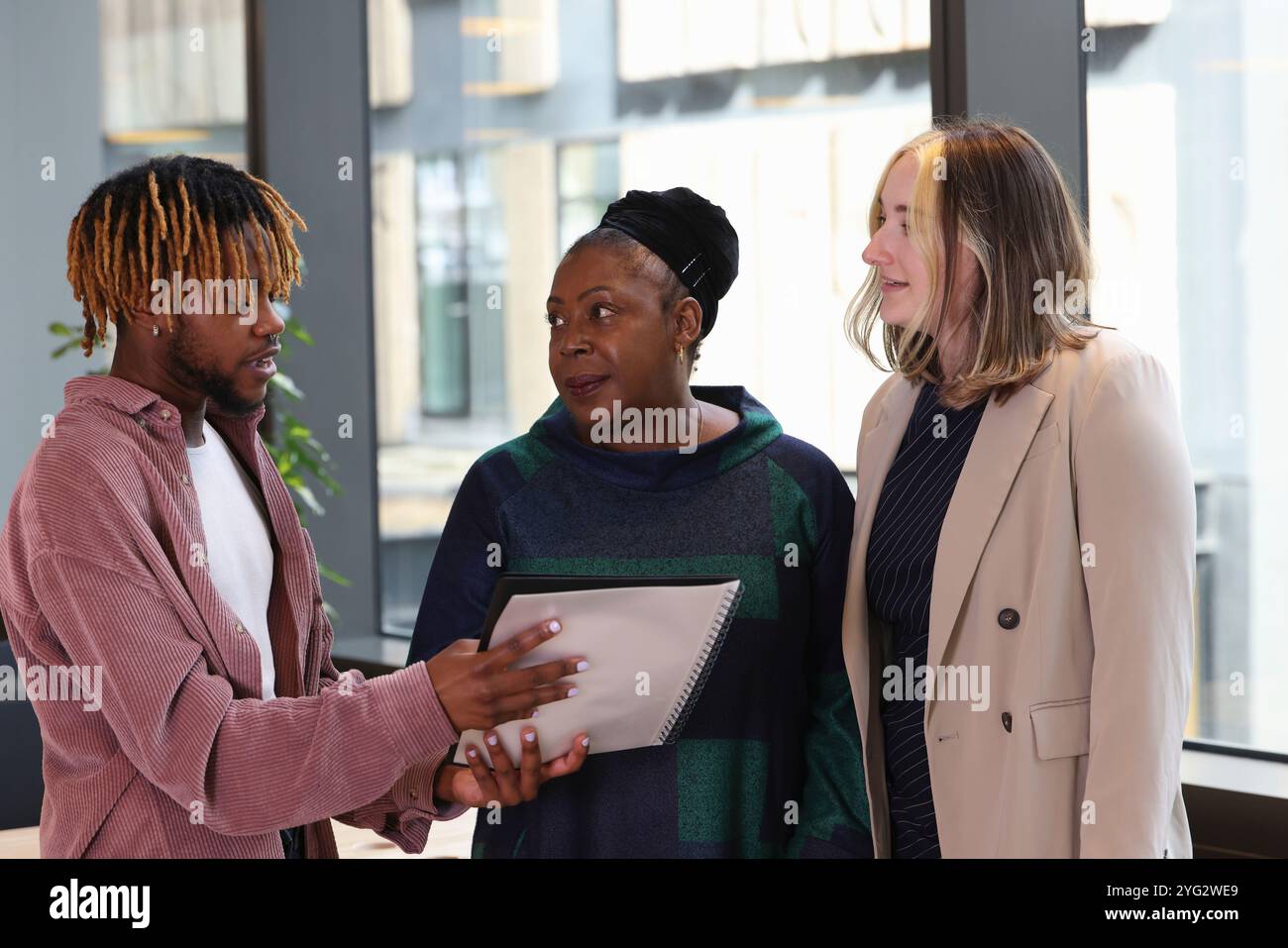 Two businesswomen and businessman discussing in office Stock Photo