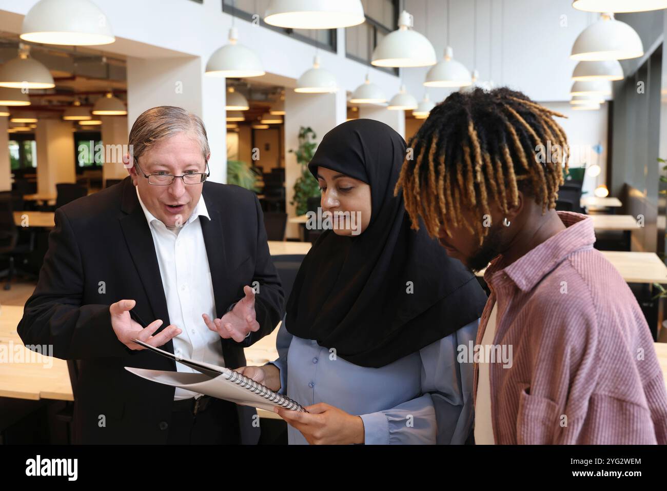 Two businessmen and businesswoman discussing in office Stock Photo
