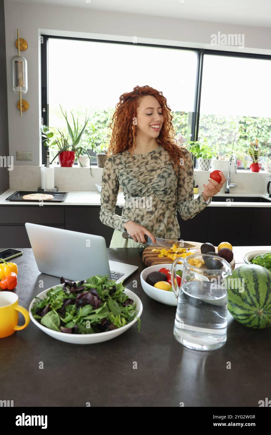 Woman cutting vegetables in kitchen Stock Photo