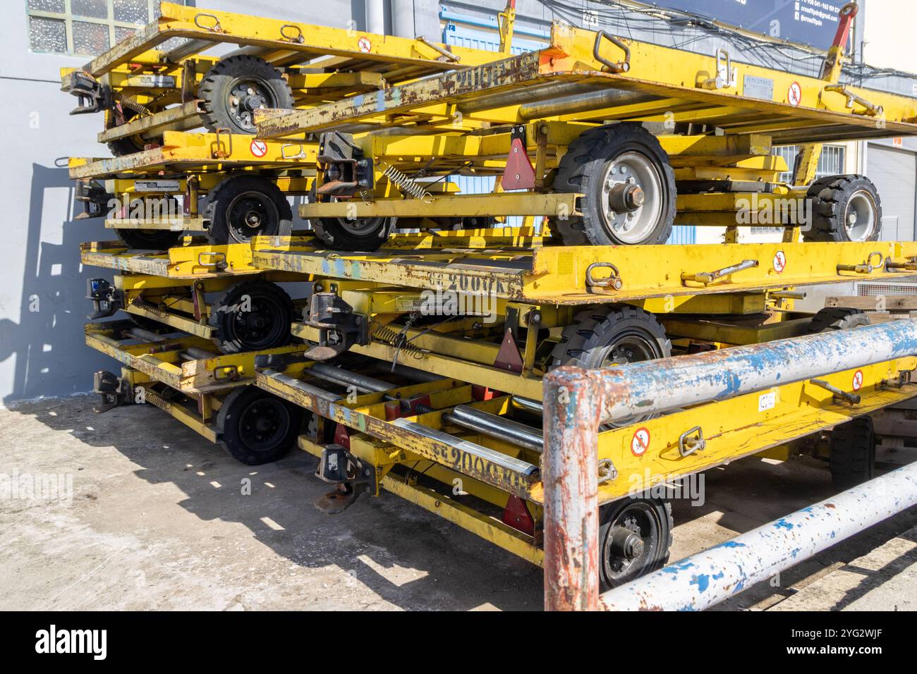 Yellow industrial trailers stacked and ready for transportation and logistics operations in a warehouse area Stock Photo