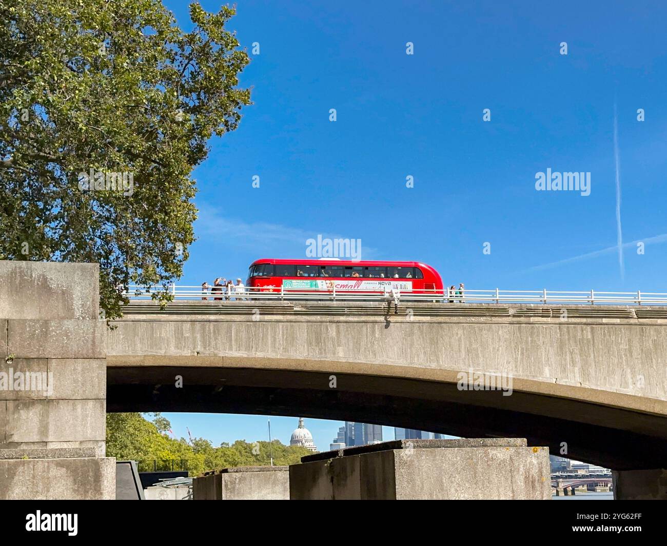 London, England, UK - 23 August 2023: Scenic landscape view of a red London bus driving on one of the road bridges over the River Thames - Smartphone Captured Stock Image