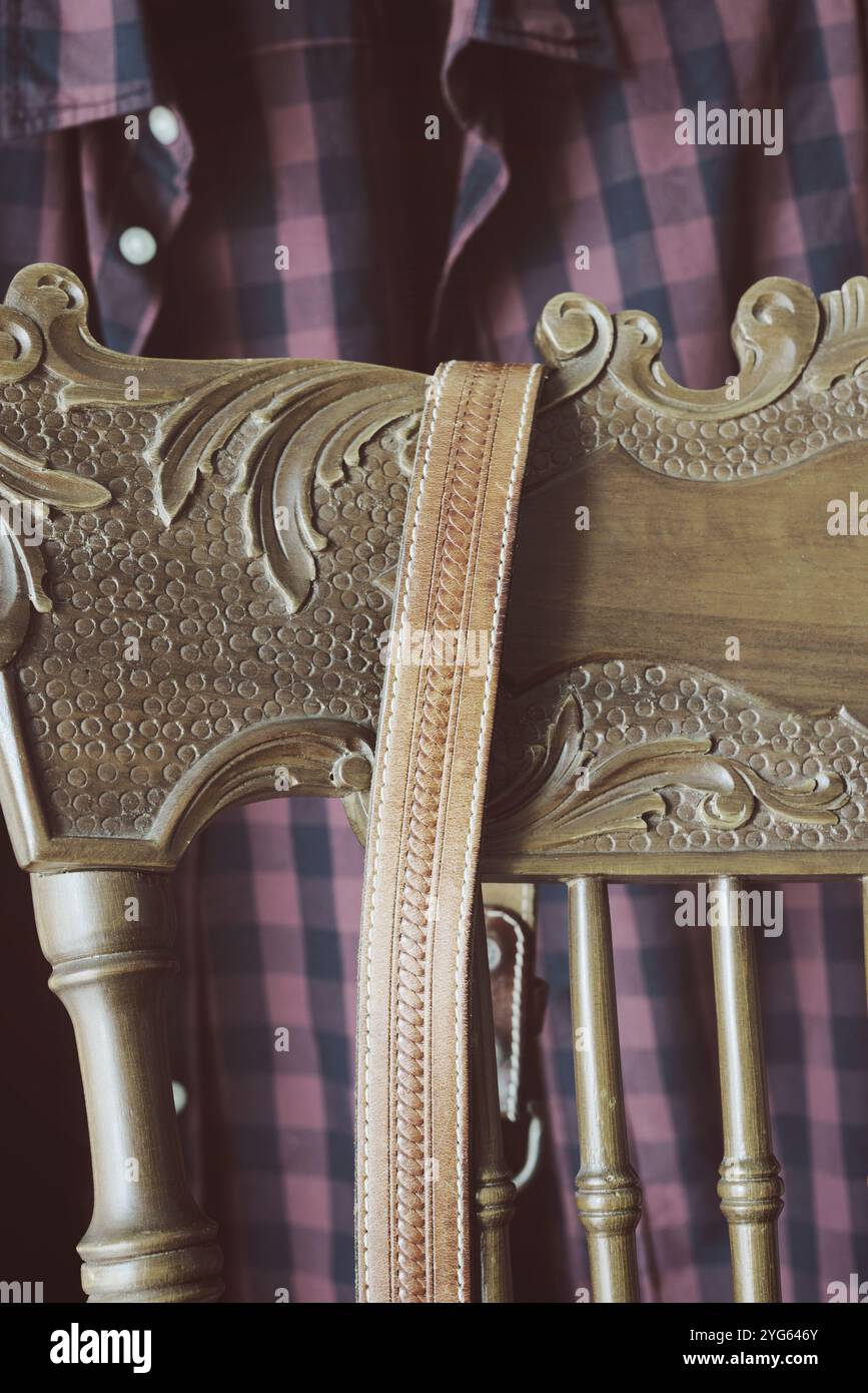 male checked shirt and leather belt hanging on chair Stock Photo