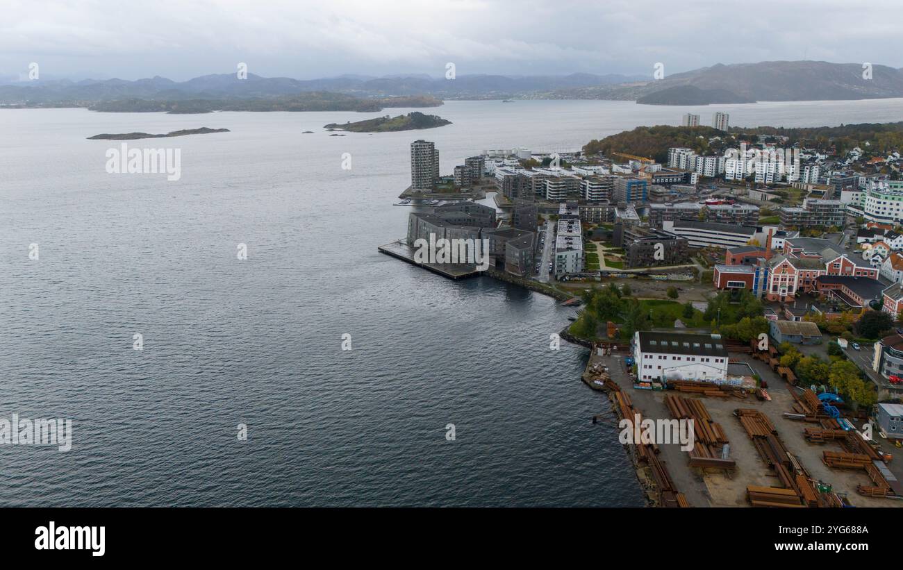 Aerial view of a coastal city with modern buildings, a harbor, and ...