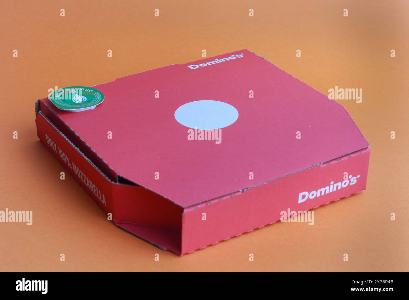 London, United Kingdom, 5th November 2024:- A view of Domino’s 9' Pizza, against an Orange Background Stock Photo