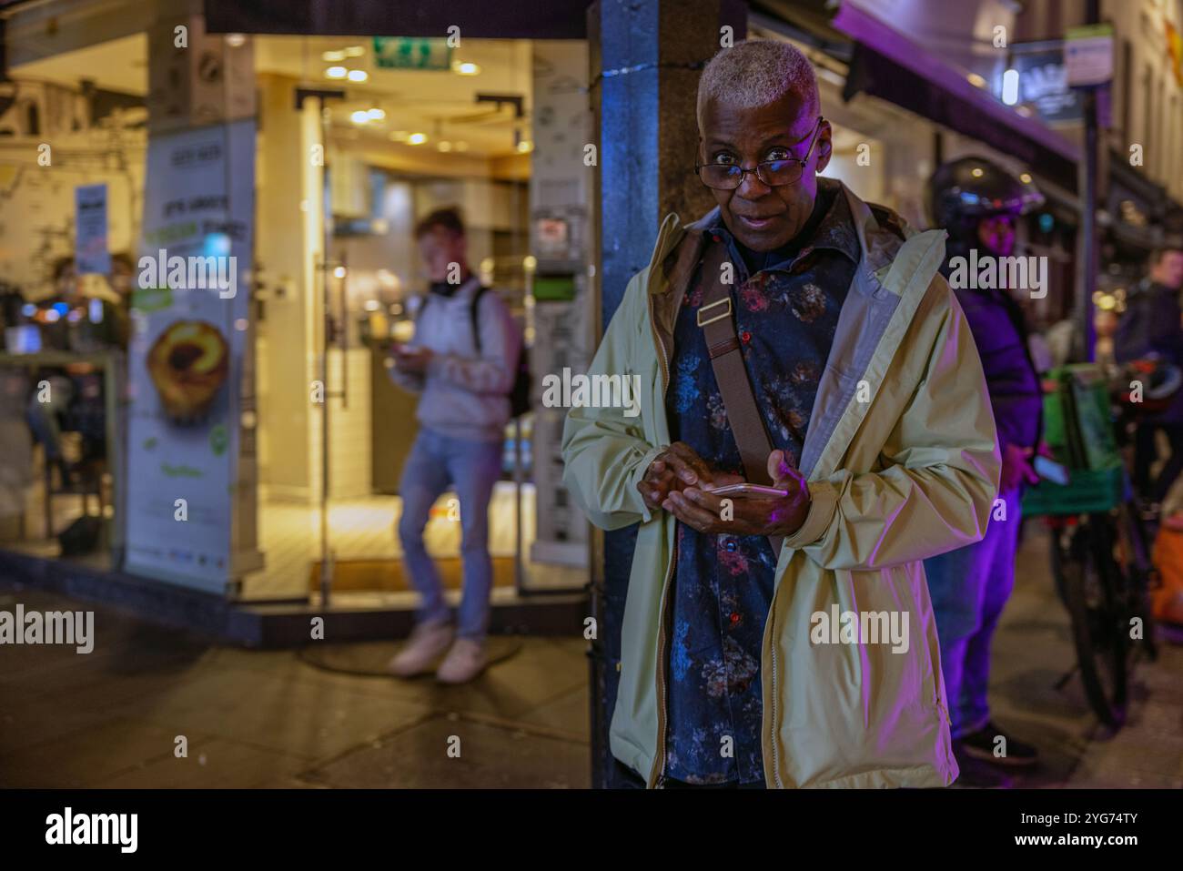 Man standing in street and using his smartphone Stock Photo