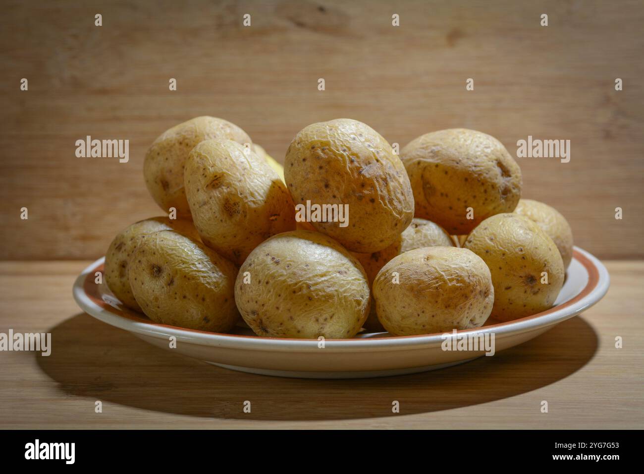 Concept photo of cooked potatoes in front of a brown rustic woden ...