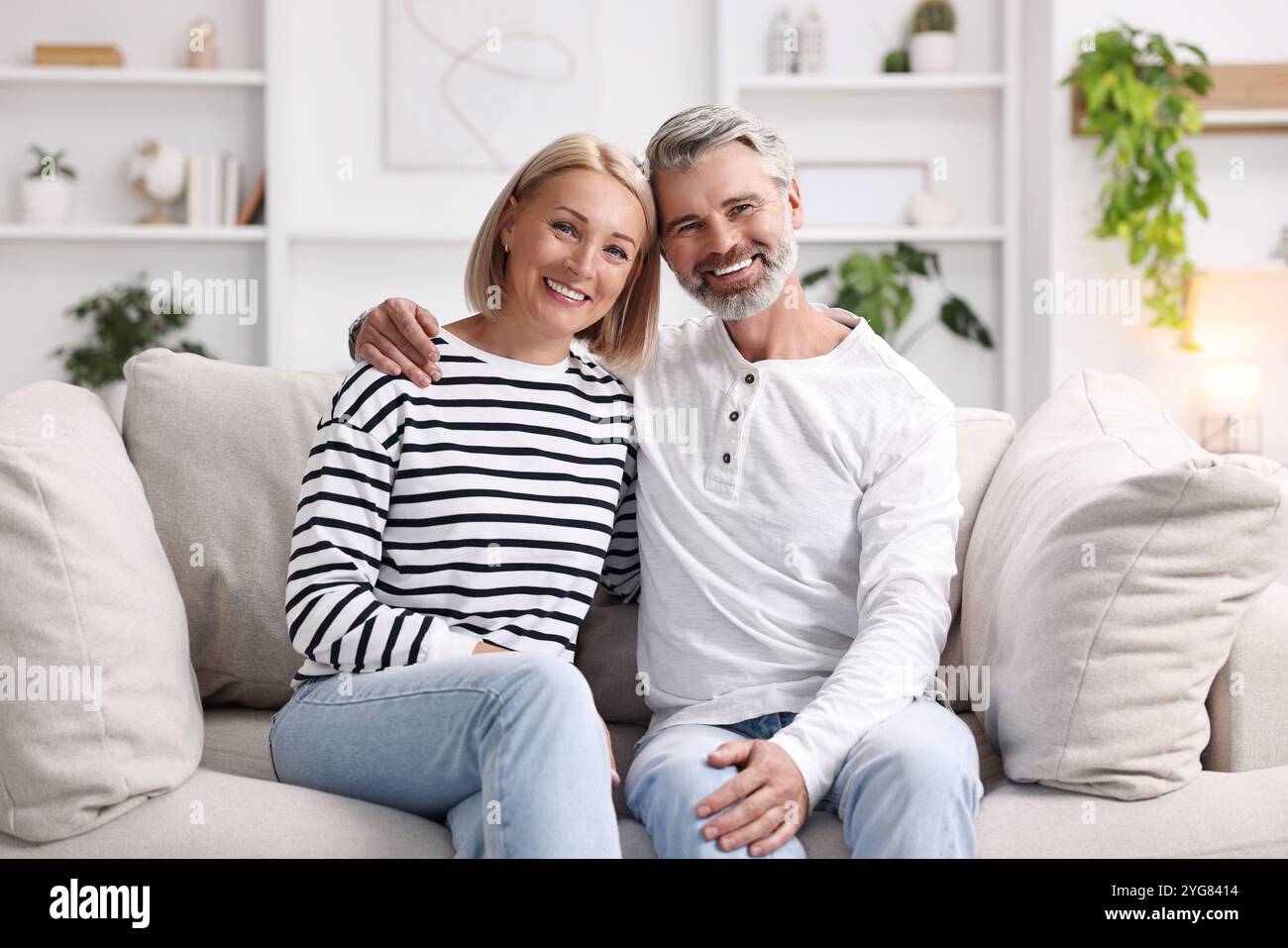 Happy middle aged couple on sofa at home Stock Photo - Alamy