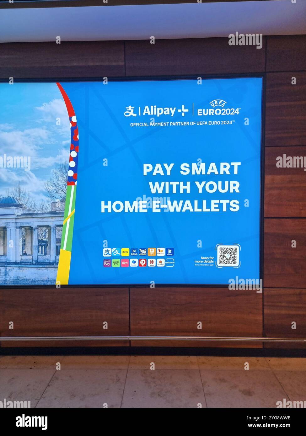 Commercial banner / display in Berlin Brandenburg Airport for Alipay home e-wallets during Euro2024 - Smartphone Captured Stock Image
