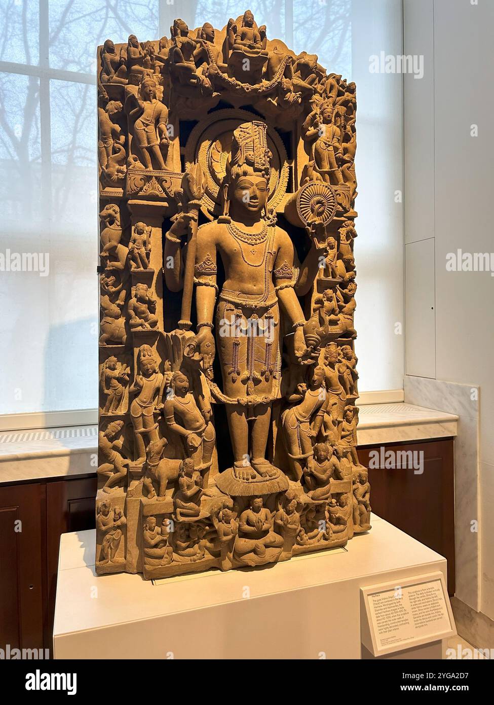 he image shows a detailed stone sculpture of a Hindu deity, likely from an ancient Indian temple. The sculpture is intricately carved with numerous sm - Smartphone Captured Stock Image