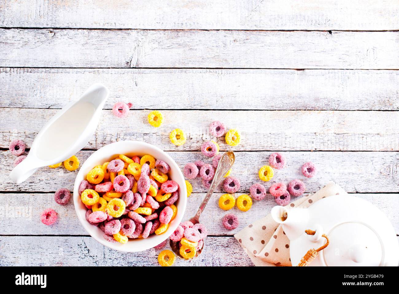 Falling colorful corn rings in bowl on white table Stock Photo