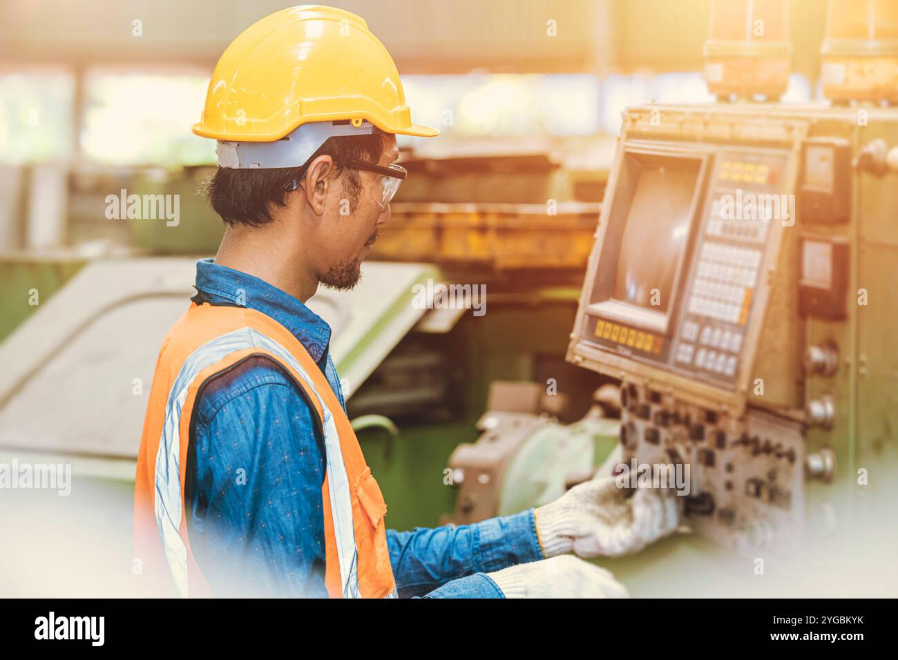 Engineer worker program setup CNC machine in metal industry factory with tablet technology. Stock Photo