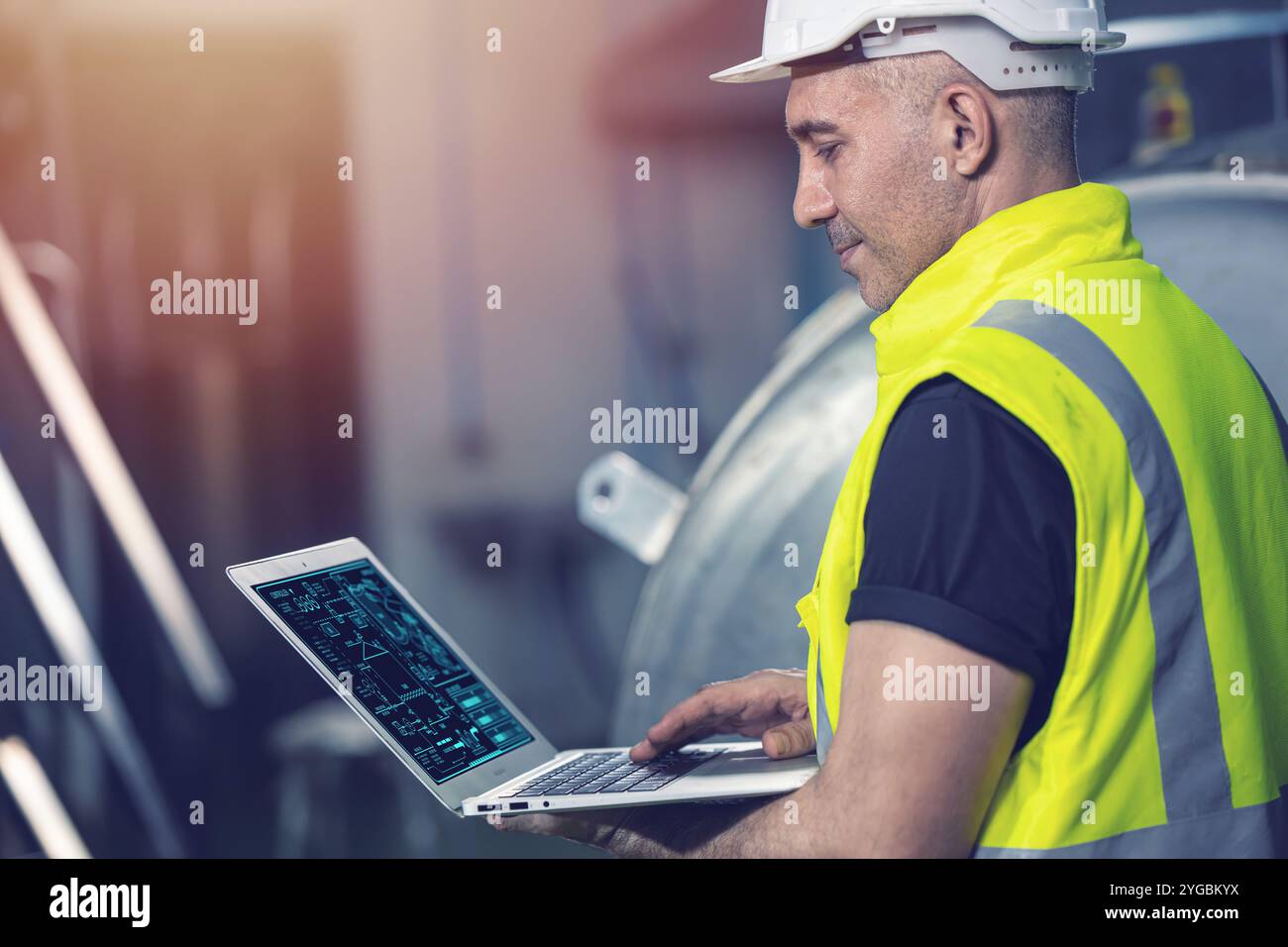 Smart Engineer using laptop computer software program application to help support work service machine on site factory. Stock Photo