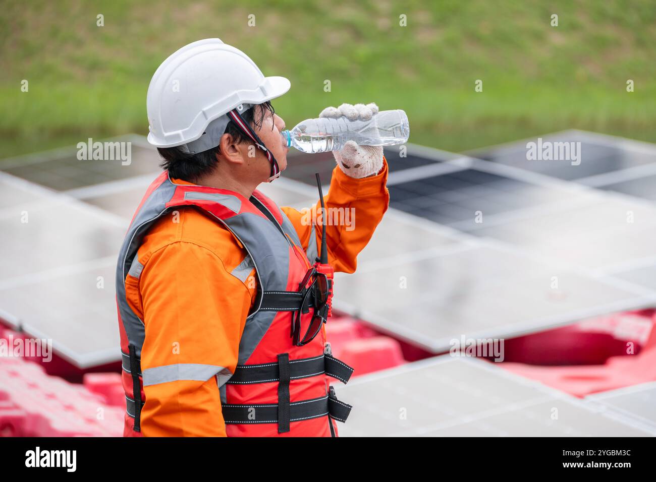 Tired Engineer Worker Man Drinking Water Control Operate Floating Solar Farm Outdoors. Stock Photo