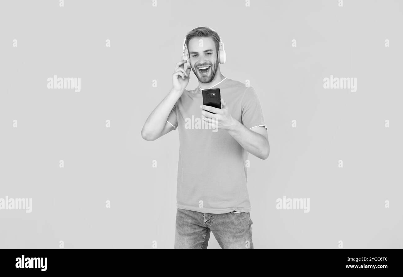 Feel the music you are listening. Happy guy listen to mobile music on phone. Listening to podcast Stock Photo