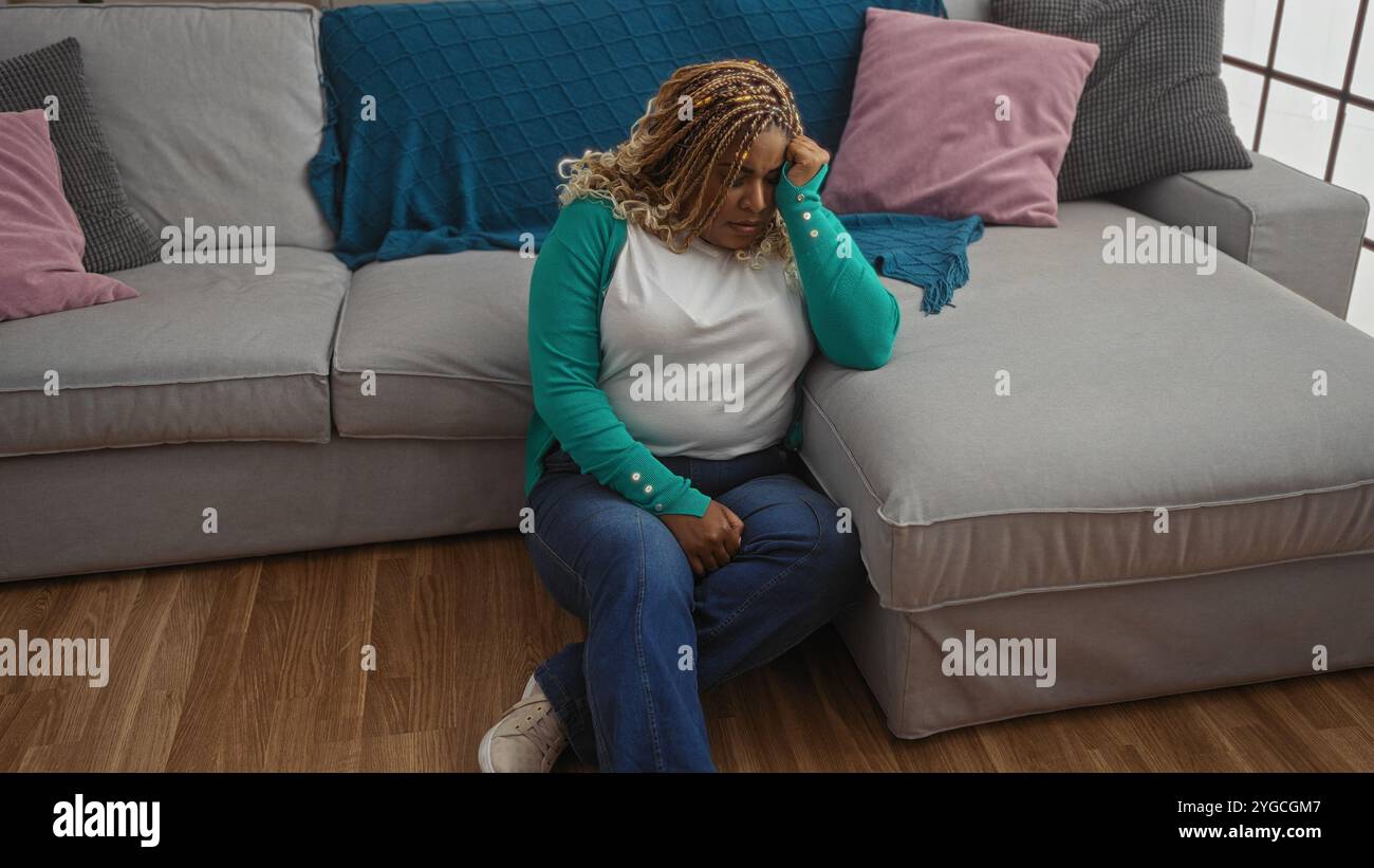A young african american woman with braids sitting in a living room ...