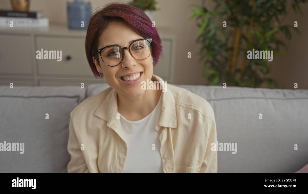  A beautiful young woman with short hair and glasses is smiling indoors ...