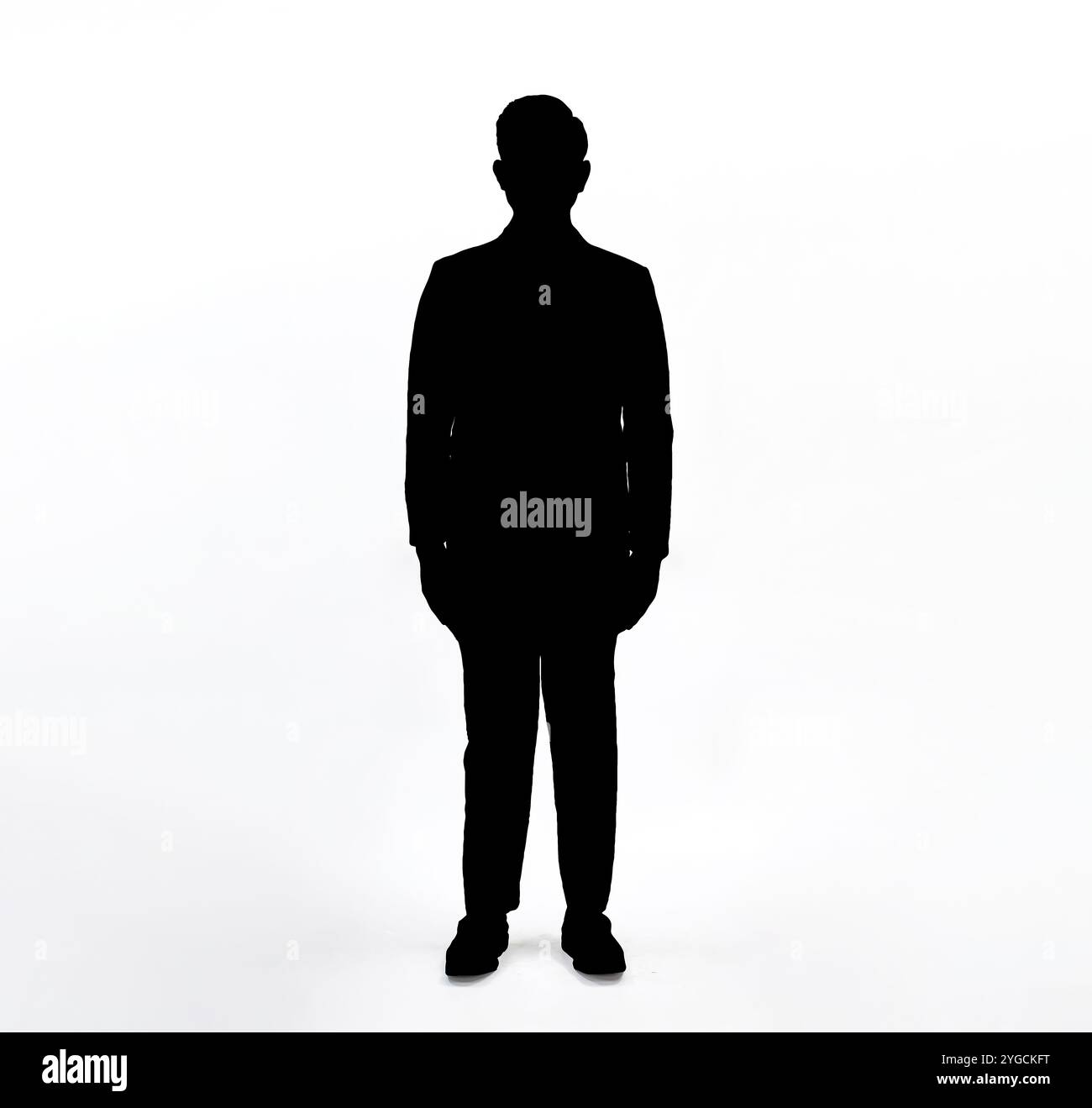 Silhouette of man standing, black color isolated on white background.Man in suit standing with hands against the body isolated vector silhouette. Stock Photo