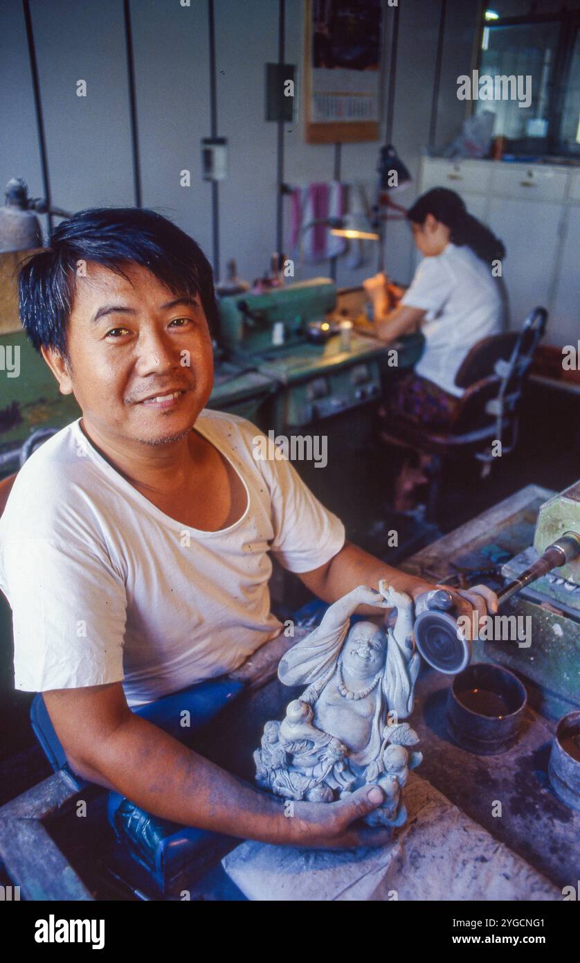 China, Beijing, Craftsman at work to creaite a Buddha statue. Stock Photo