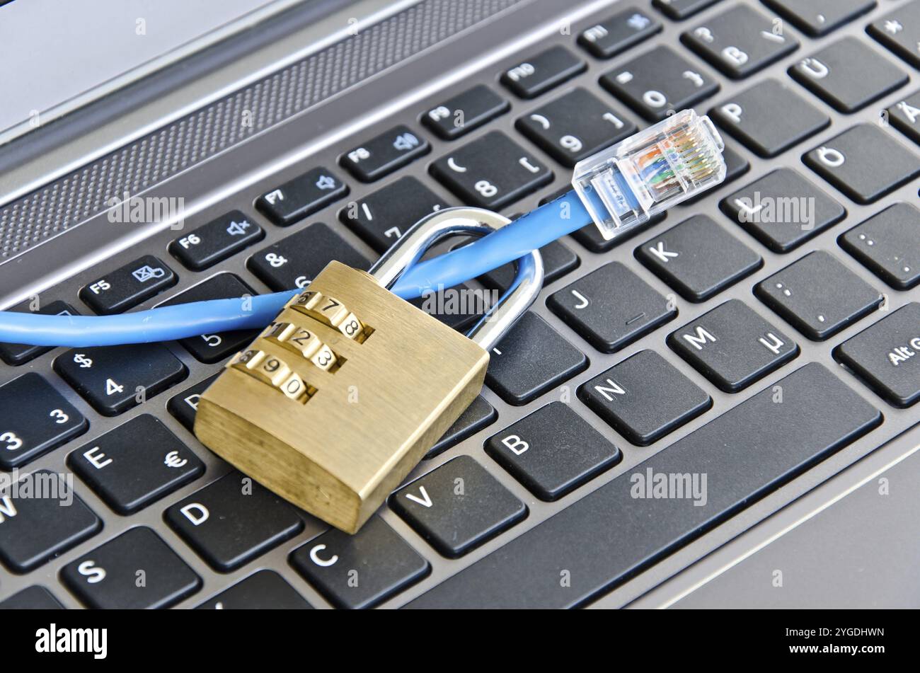 Internet cable and padlock on computer keyboard symbolizing data security Stock Photo