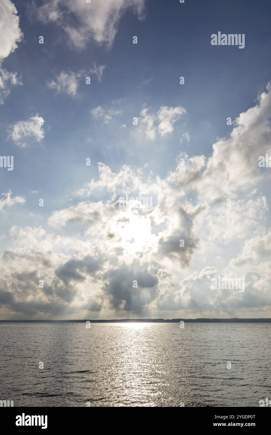 Sun shining dramatically through the clouds over the ocean Stock Photo