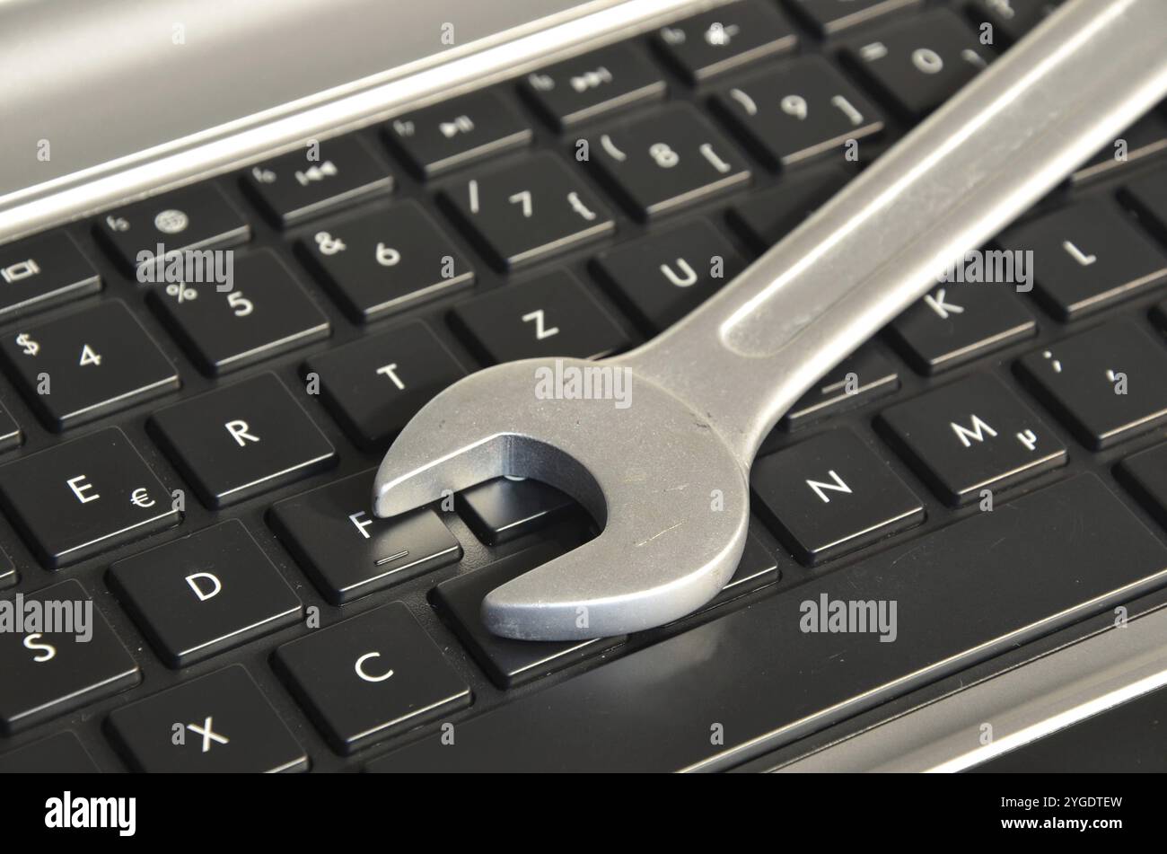 Wrench lying on computer keyboard symbolizing IT maintenance Stock Photo